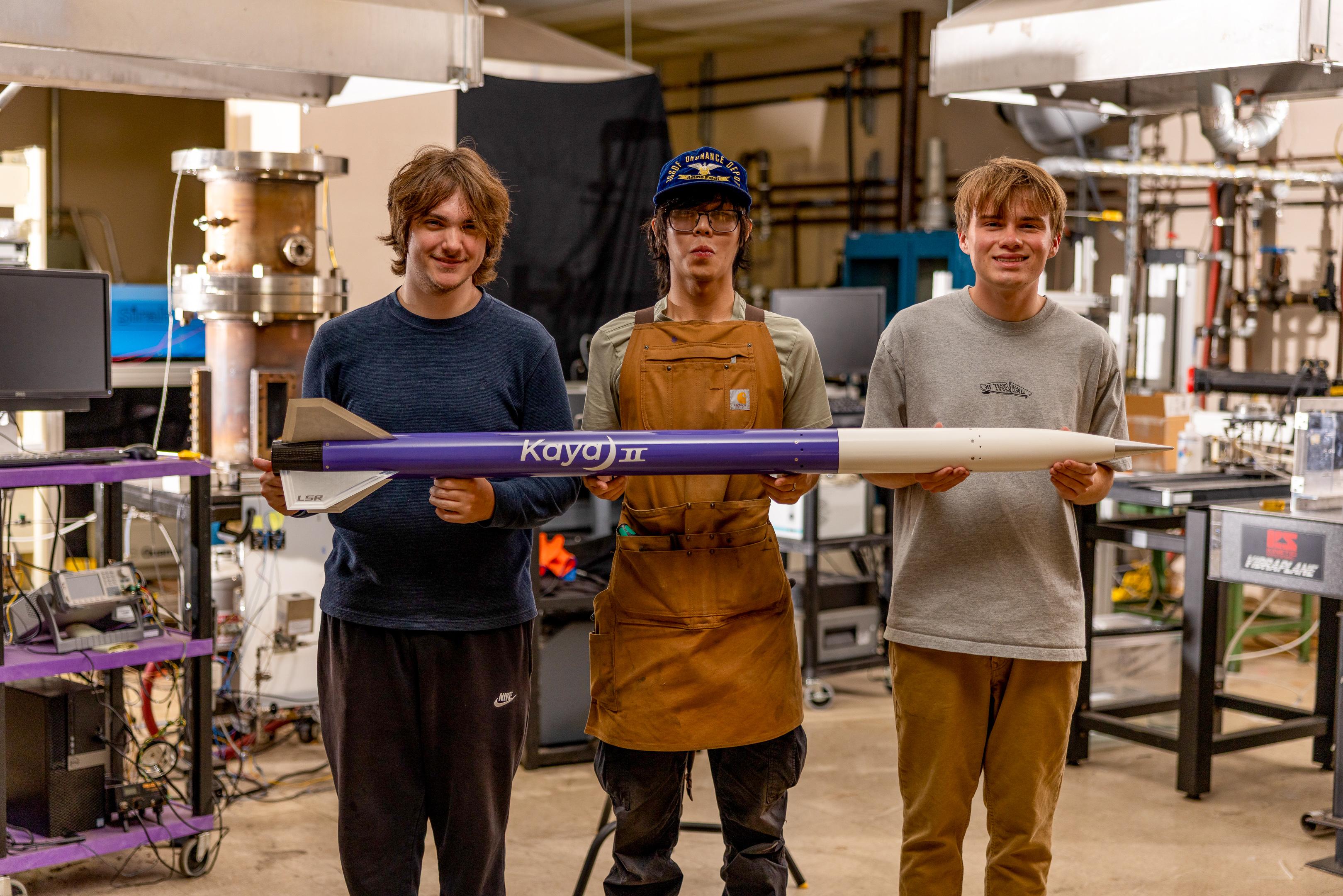 Three members holding Kaya II in the lab