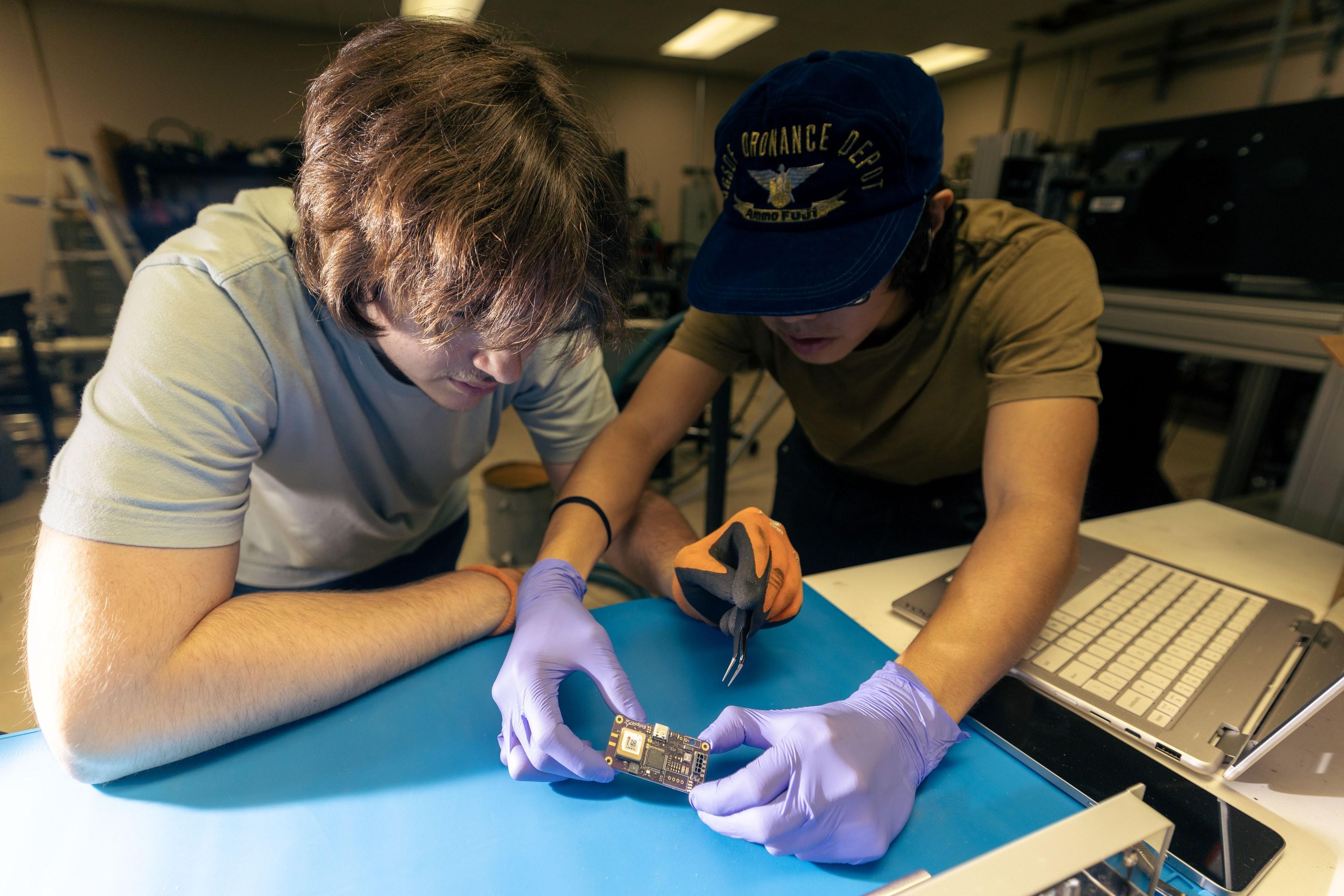 Two members inspecting a flight computer